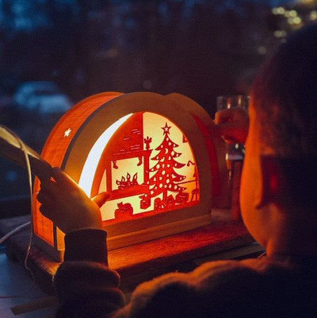 Kerstfeest silhouet in houten silhouetlamp aan met kindje